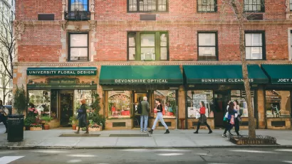 Greenwich Village street with red brick buildings with green awnings and businesses on first floor